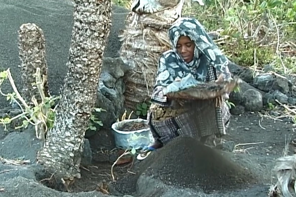 Femme tamisant du sable